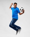 Man or football fan with soccer ball jumping