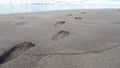 Man footprint on beach shore sand go away from land to the sea Royalty Free Stock Photo