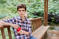 Man in the forest in wooden summerhouse with red paper cup Royalty Free Stock Photo