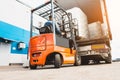 A man on a forklift works in a large warehouse, unloads bags of raw materials