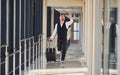 Man in formal clothes and with baggage is running forward and busy for a plane Royalty Free Stock Photo