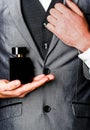 Man in formal suit, bottle of perfume, closeup. Fragrance smell. Men perfumes. Fashion cologne bottle. Man holding up Royalty Free Stock Photo