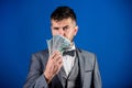 Man formal suit hold pile of dollar banknotes blue background. Businessman got cash money. Richness and wellbeing Royalty Free Stock Photo