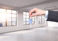 A man in formal suit holds a key in a modern loft panoramic apartment or office. Rent or buy new home or office. New York view. Royalty Free Stock Photo