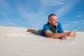 Man found a water bottle in the desert and smiling happily