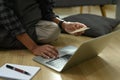 Freelancer sitting on floor in living room and working with computer laptop. Royalty Free Stock Photo