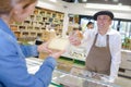 Man in French atire passing cheese to customer Royalty Free Stock Photo