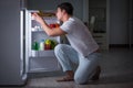 The man at the fridge eating at night Royalty Free Stock Photo