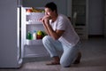 The man at the fridge eating at night Royalty Free Stock Photo