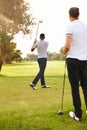 Man, friends and swing with club on golf course for sports game, outdoor match or competition on green grass. Rear view Royalty Free Stock Photo