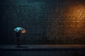 Man in front of brick wall at night with umbrella on a rainy day illuminated by a street lamp. Royalty Free Stock Photo