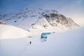 A man in front of the entrance to an ice cave in Iceland. A walk on the glacier. High mountains and clouds at dawn. Royalty Free Stock Photo