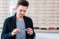 Man in front of shelf with glasses in optician shop Royalty Free Stock Photo