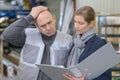 man frowning while looking at folder held by woman Royalty Free Stock Photo