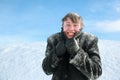 Man froze and hides head in collar of overcoat