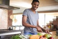 Man, fruit and vegetables with knife in portrait for cooking, salad and happy in home kitchen. African person, smile and Royalty Free Stock Photo