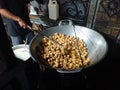 man frying cripsy tofu at big pan, using used cooking oil or minyak jelantah