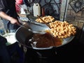 man frying cripsy tofu at big pan, using used cooking oil or minyak jelantah