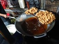 man frying cripsy tofu at big pan, using used cooking oil or minyak jelantah