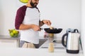 Man with frying pan cooking food at home kitchen Royalty Free Stock Photo