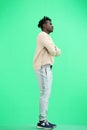 A man, full-length, on a green background, crossed his arms Royalty Free Stock Photo