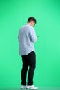 A man, full-length, on a green background, with a phone Royalty Free Stock Photo