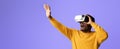 Man Enjoying Virtual Reality Experience While Wearing Headset Against Purple Background Royalty Free Stock Photo