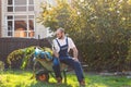 Man-gardener resting after cleaning the yard. Smile and relax after work. Gardening and cleaning