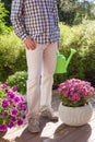 Man gardener holding watering can in garden