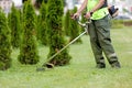 Landscaper worker cutting grass with string lawn trimmer Royalty Free Stock Photo