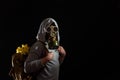 Man in gas mask with flowers in backpack. Enviromental pollution, nature protection, ecology disaster and hope concept.