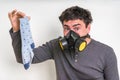 Man with gas mask is holding dirty stinky sock Royalty Free Stock Photo