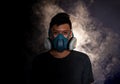 Man in a gas mask smokes ,black background