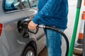 Man at the gas station filling the tank of his car with diesel to the top level before a long journey