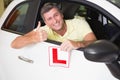 Man gesturing thumbs up holding a learner driver sign Royalty Free Stock Photo