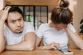 Man gets bored as woman chats on the phone for long time. Asian couple in cafe Royalty Free Stock Photo