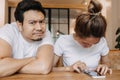 Man gets bored as woman chats on the phone for long time. Asian couple in cafe Royalty Free Stock Photo