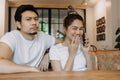 Man gets bored as woman chats on the phone for long time. Asian couple in cafe Royalty Free Stock Photo