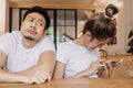 Man gets bored as woman chats on the phone for long time. Asian couple in cafe Royalty Free Stock Photo