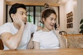 Man gets bored as woman chats on the phone for long time. Asian couple in cafe