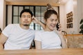 Man gets bored as woman chats on the phone for long time. Asian couple in cafe Royalty Free Stock Photo