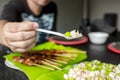 A man gets a spoonful of raw scallops and chili. Sampling Kinilaw na Scallops Royalty Free Stock Photo