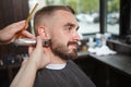 Man getting beard cut by professional barber