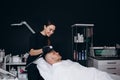 Man getting facial nourishing mask by beautician at spa salon. Apply face mask, spa beauty treatment and skincare Royalty Free Stock Photo