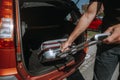 Man getting ready for holiday, vacation, putting a luggage into the car trunk, leisure time, tourism concept Royalty Free Stock Photo