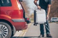 Man getting ready for holiday, vacation, putting a luggage into the car trunk, leisure time, tourism concept Royalty Free Stock Photo