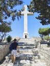 Man getting to the huge Cross on top of the path. Royalty Free Stock Photo