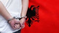 A man getting under arrest in Albania. Concept of being handcuffed, detained, incarcerated and jailed in said country. National