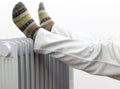 A Man Getting warm in cold winter days. Two feet placed on a heater for warmth. Royalty Free Stock Photo