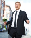 Man, gift and valentines day flowers or roses on a city street for a date, love and motivation. Model person in a formal